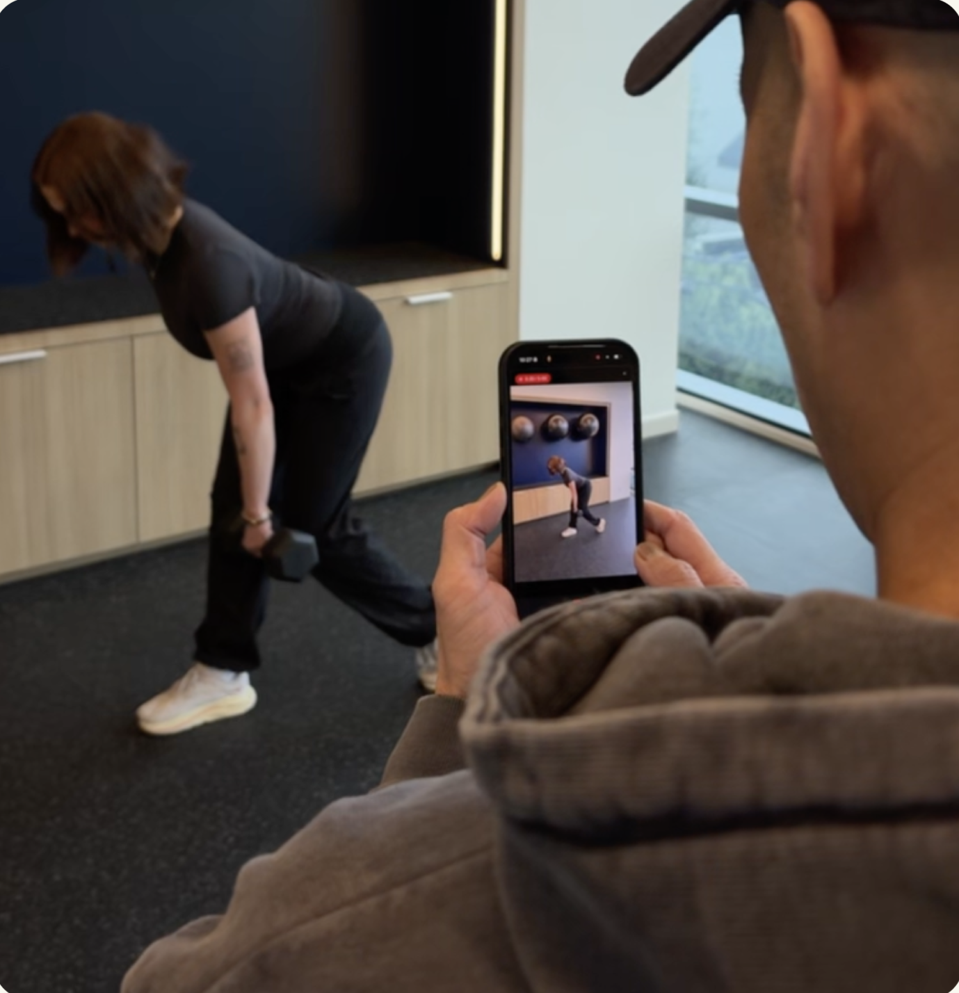 A clinician recording an exercise demonstration with a patient